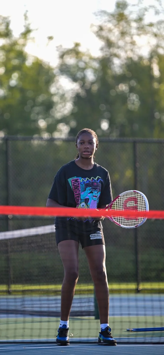 A young player with her racket at the net