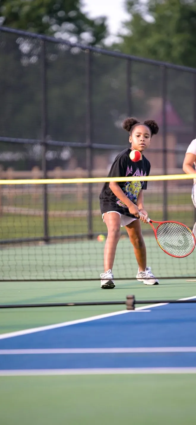 A young player preparing to return a tennis ball