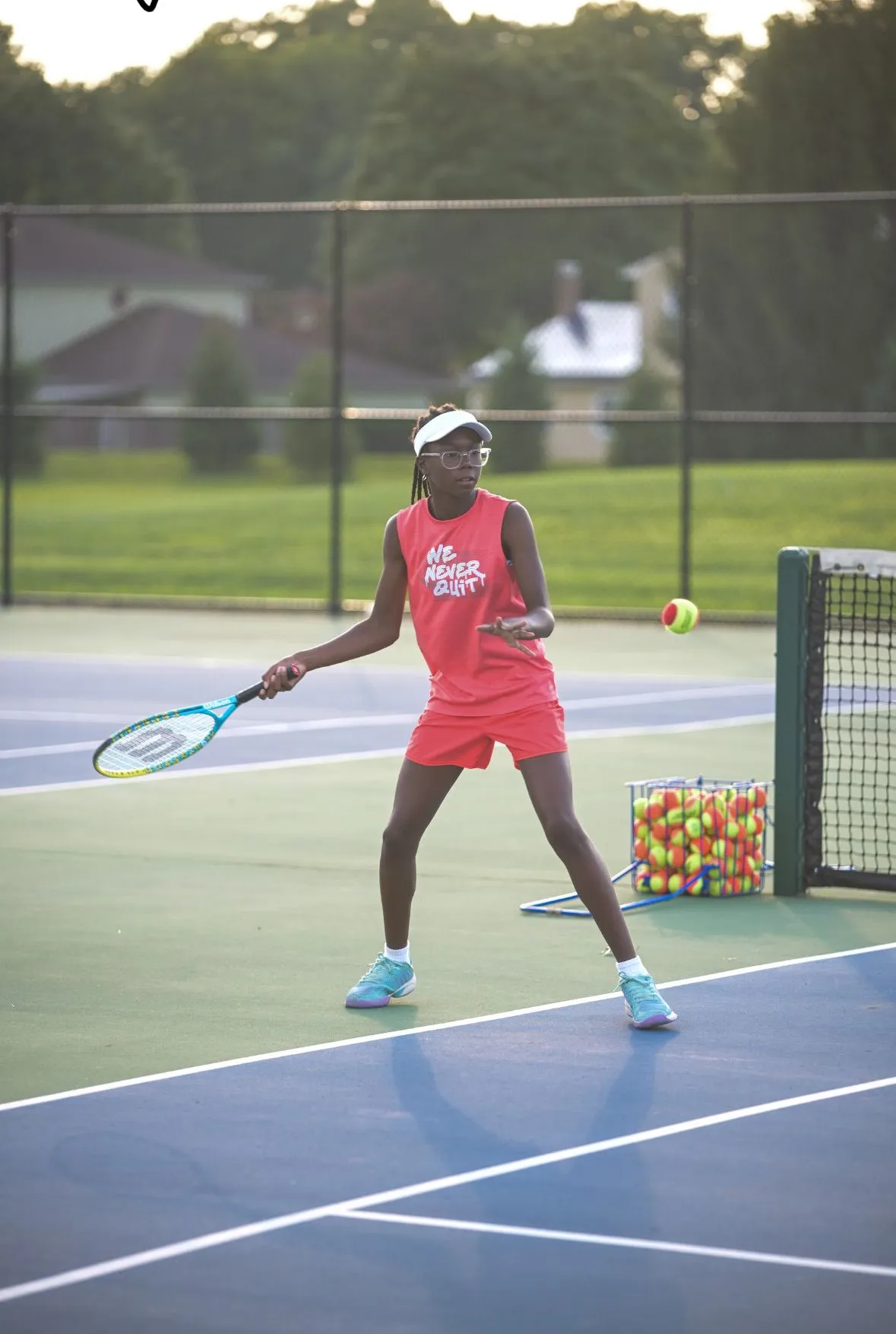 A young player practicing her tennis serve