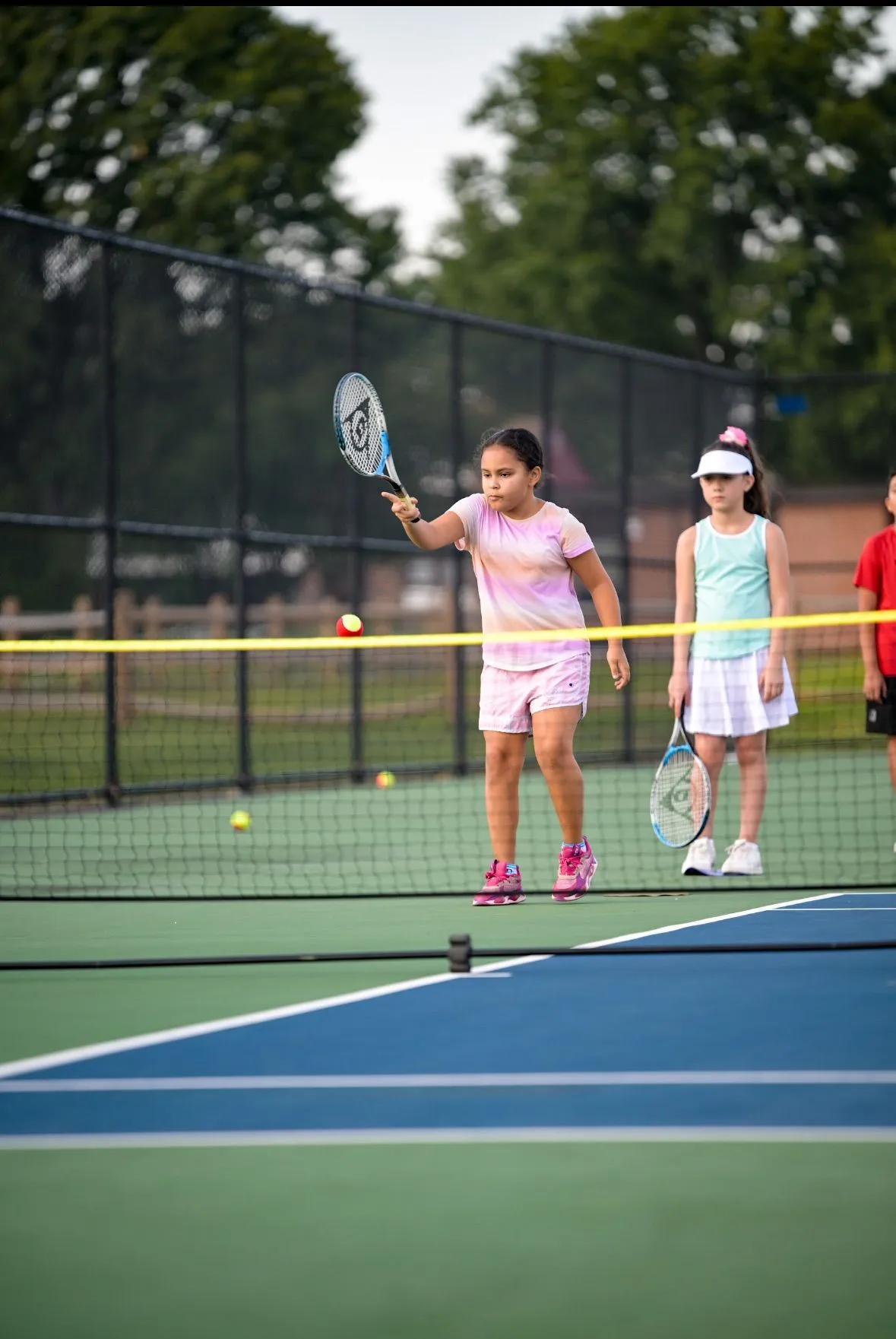 Two girls playing tennis together