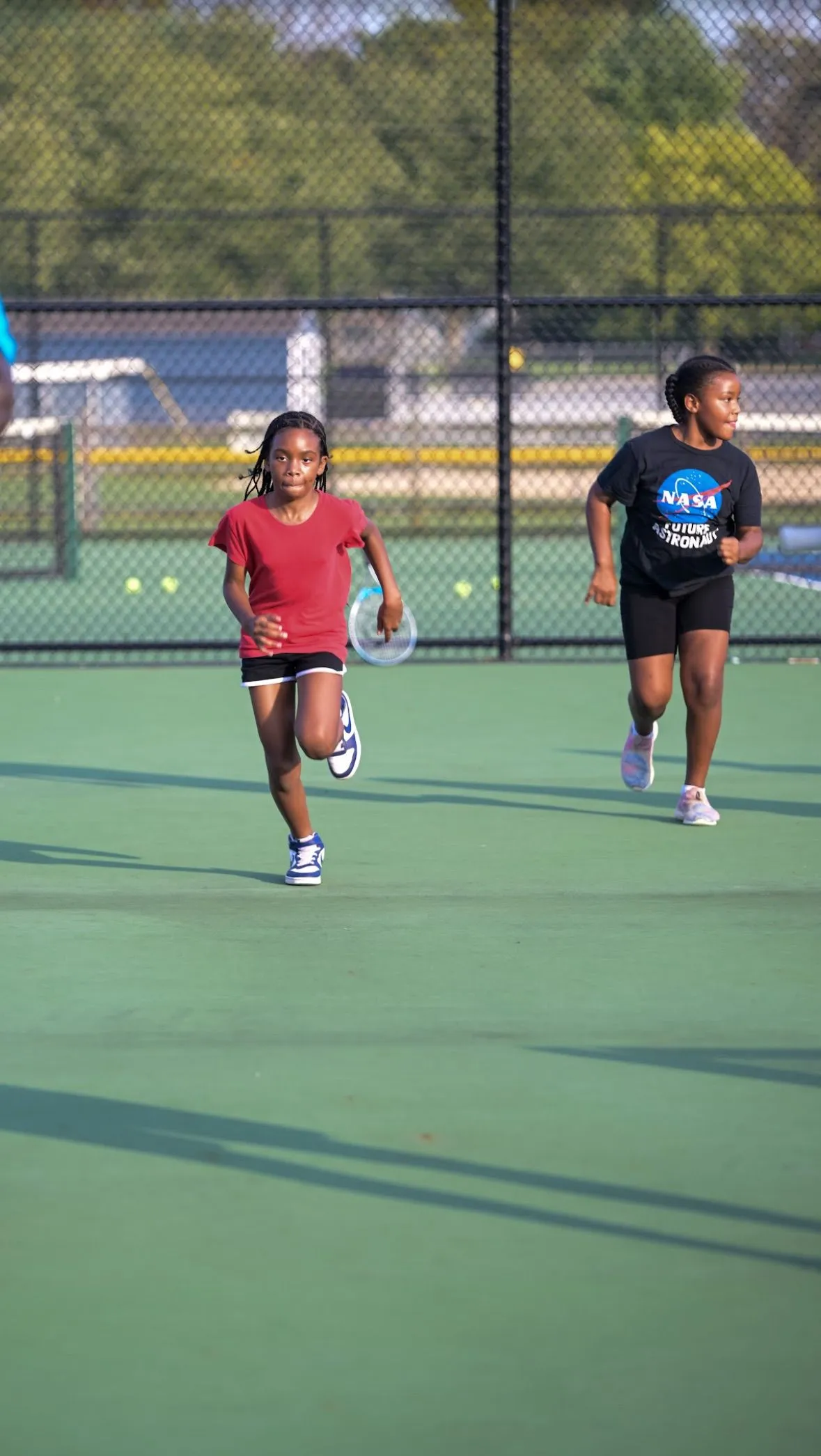 Two girls running during tennis practice