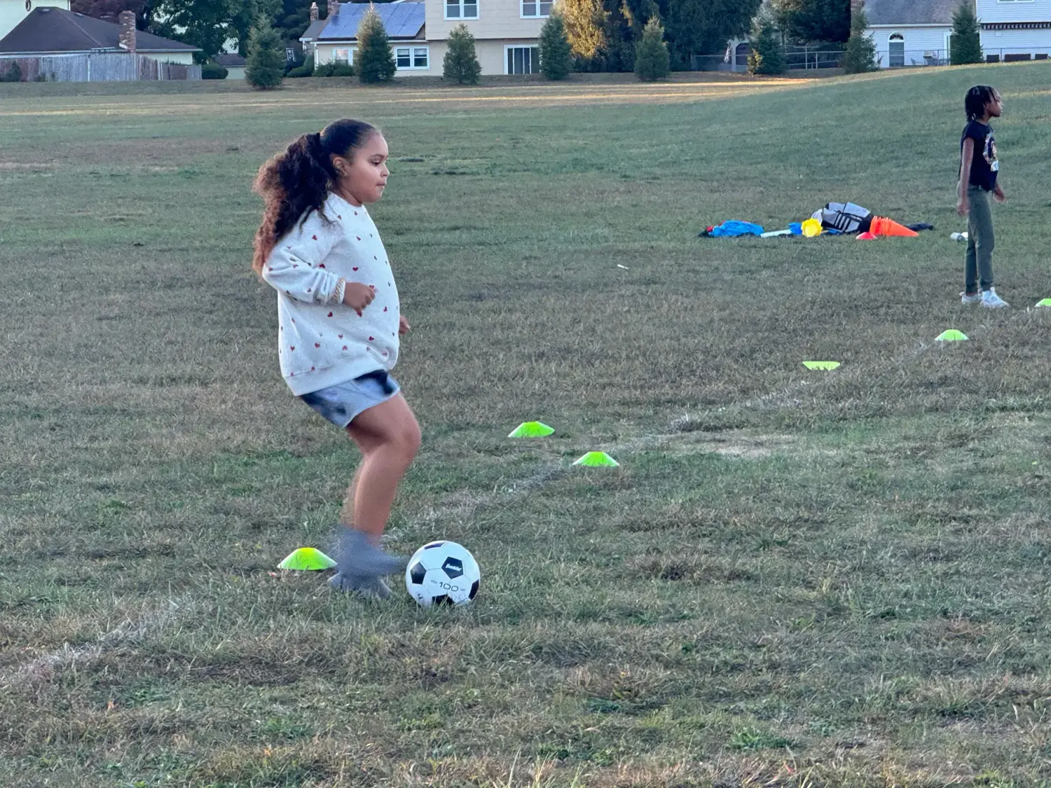 A young girl practicing soccer during a She Leads Sports clinic