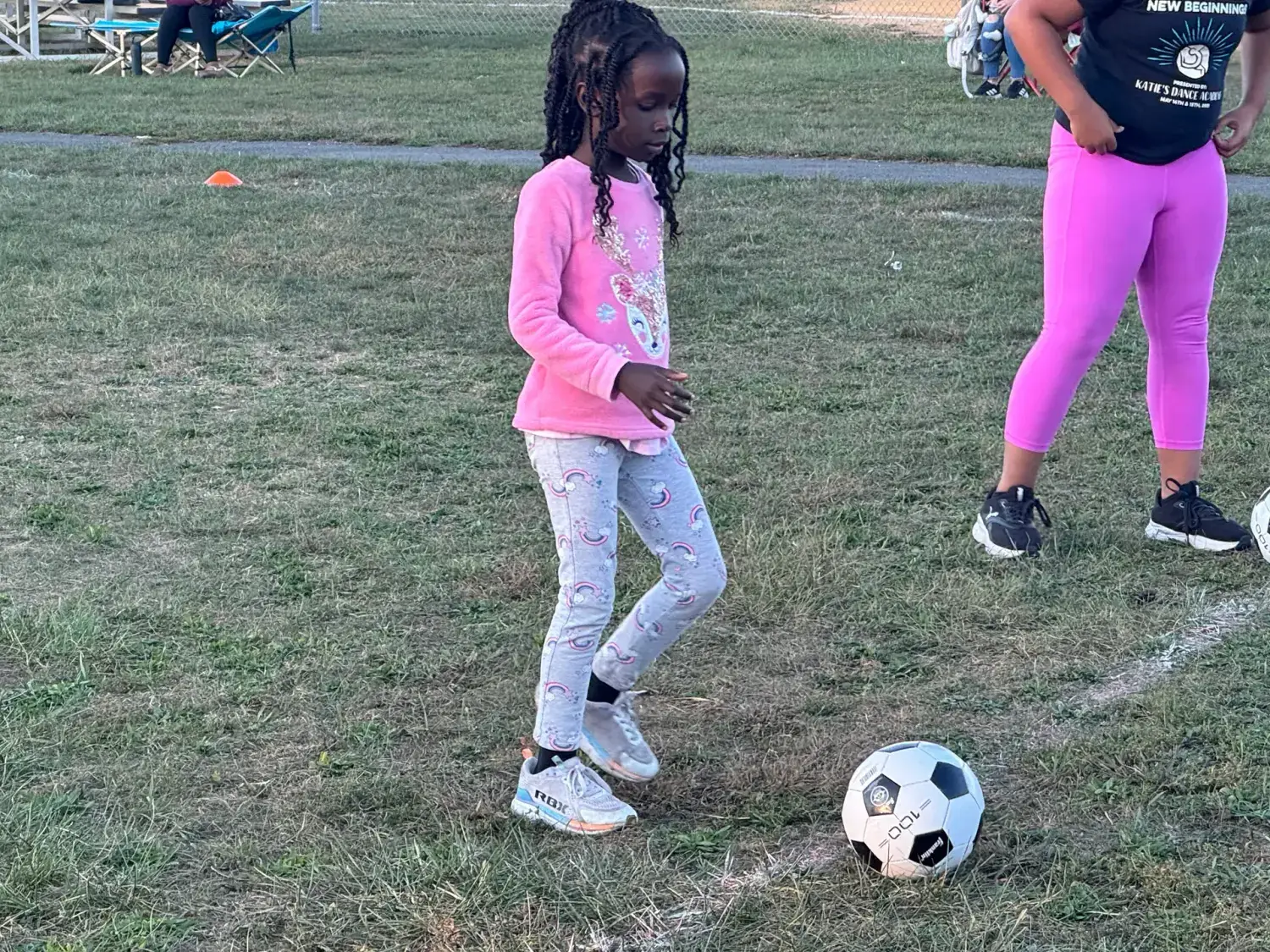 A young girl working on ball control at a sports clinic