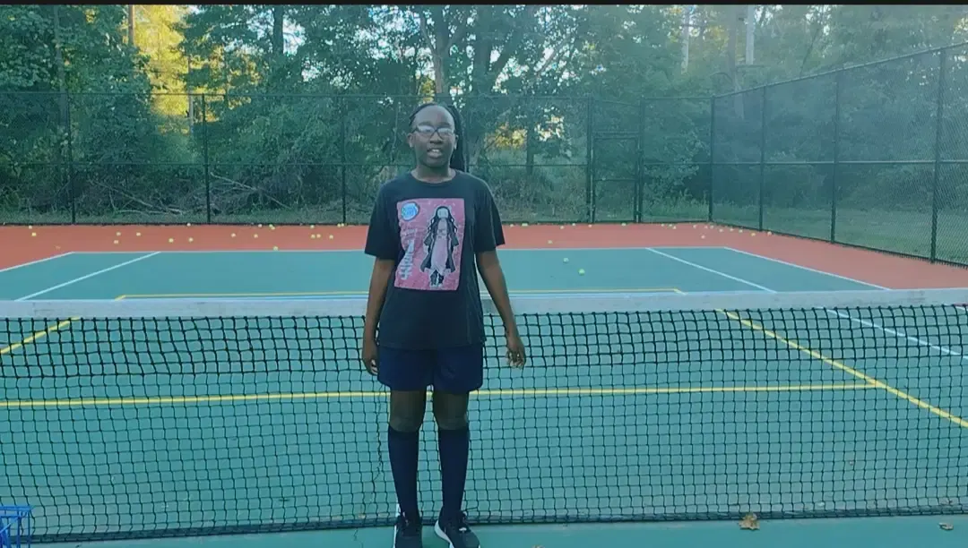 A young athlete at the tennis net